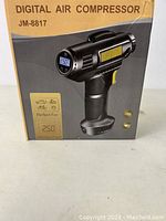 Box of the digital air compressor JM-8817 showing product name, image, and key features such as USB charging and digital pressure display.