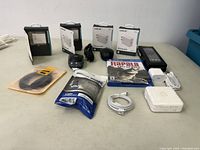 Overview of all electronic accessories on table including Apple charger, PS4 game, adapters, cables, and controller