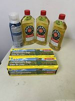 The full lot on display showing 2 boxes of Biosak compostable green bin liners, 3 bottles of Murphy's Oil Soap wood cleaner, and 1 can of Scotchgard spray.