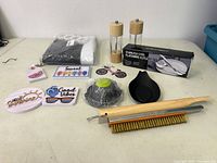 Full view of lot including salt and pepper grinders, shower curtain shampoo, decorative tags, cleaning brushes, and boxed cutlery set.