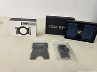 Photo of Ridge wallet with accessories including the phone mount adapter box and two small accessories in plastic bags.