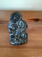 Front view of the Inuit stone carving showing the two figures in traditional clothing seated together.