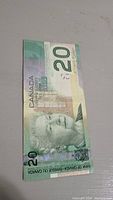 Front side of Canadian $20 bill from 2004 showing Queen Elizabeth II portrait and denomination.
