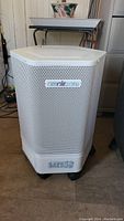Front view of Amaircare 3000 air purifier showing perforated housing, brand logo, and control panel on bottom.