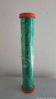 Front full view of the green plastic wrap roll standing upright on a flat surface