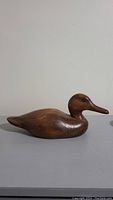 Side view of the wooden duck decoy, showing smooth wood grain and natural finish.