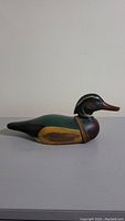 Side profile view of the hand painted wooden duck decoy showing detailed color and shape.