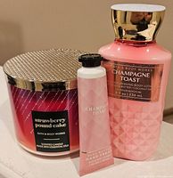 Photo showing Strawberry Pound Cake scented candle, Champagne Toast nourishing lotion, and Champagne Toast hand cream, all new and from Bath & Body Works.