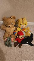 Lot of six small vintage plush toys including two bears, a yellow circus character, a red-uniformed character, a grey elephant, and a black whale.