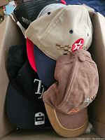 Box view showing stacked hats, highlighting variety and logos.