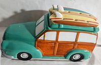 Side view of teal and wood-toned ceramic wax warmer in shape of coastal cruiser car with two surfboards on roof