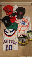 Full lot showing various hats, jerseys, souvenir football, and tumbler