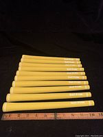 Photo showing all 10 yellow Golf Pride iron grips aligned, with a ruler showing approximate length.