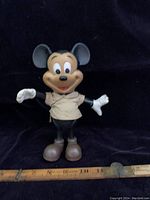 Front view of the vintage Mickey Mouse figurine standing beside a measuring tape showing 7.5 inches height.