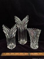 Three clear crystal Mikasa vases grouped with a ruler for size reference, displayed against black background.