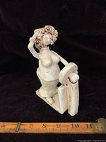 Front view of the clay sculpture showing the female figure and scale, with ruler for size reference.