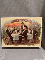Vintage Sunset Club humidor with painted scene of men gathered at a dining table under a sunset