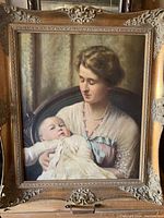 Full view of the oil on canvas painting showing mother holding baby in ornate gold-tone frame.