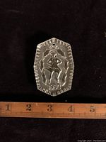 Front side of Waterford crystal ornament with embossed figure and 1993 date, shown against ruler for size reference.