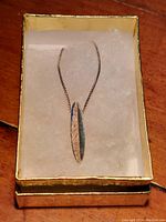Necklace laid in box showing chain and pendant arrangement.