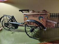 Front angled view of the vintage ice cream bicycle showing metal frame and wooden ice cream box with painted details.