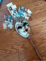 Front view of the Venetian mask showing dual-tone face and musical paper scrolls with bells