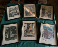 Six assorted framed pictures of Ephrata, PA shown together on a green surface, each in black wooden frames, visually confirming the lot contents as six pieces of framed artwork.