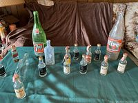 Front view of assorted vintage collectible bottles arranged on a green cloth.