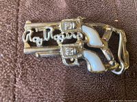 Front view of Roy Rogers child's belt buckle showing two pistols and the name in cursive.