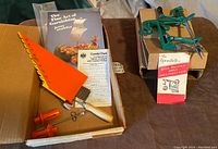 Overview of all items showing box, apple peeler, accessories, instructions, and garnishing book