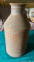 Full view of rusty vintage steel milk cream jug/can with embossed branding.