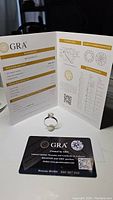 Photo of the certificate from GRA with ring and warranty card