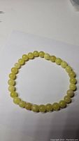Top view of the lemon jade bead bracelet on a white background showing the uniform round beads with translucent lemon yellow color.