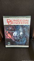 Front cover of Black Dirge's Dungeon Denizens hardcover sourcebook showing fantasy monster art and title.