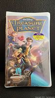 Front of the sealed VHS showing the illustrated cover art with main characters and title 'Treasure Planet'.