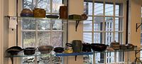 Shelves with multiple ceramic items including vases, bowls, and plates in various colors and shapes.
