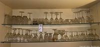 Glassfront shelf showing a variety of stemware, DOF, and highball glasses arranged in rows