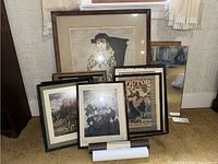 Seven framed art pieces and one mirror displayed against a wall showing the entire lot in one view.