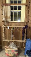 Full view of wooden peg rack with woven textiles draped