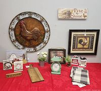 Photo showing assembled farmhouse decor items on a red tablecloth against light gray wall