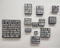 Photo of 11 black and white Primitives by Kathy wooden inspirational signs with various motivational and humorous quotes, including a floral 'Bloom' cube sign.