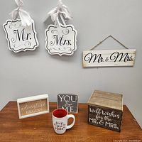 Photo showing all wedding lot items including Mr. and Mrs. hanging signs, wooden Mr. & Mrs. plaque, wishes box, a mug, and decorative plaques.
