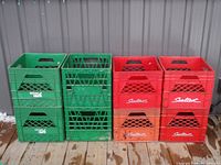 Front view of 8 vintage milk crates stacked in two columns; four green Neilson crates and four red Sealtest crates.