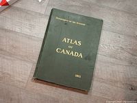Front cover of green hardcover atlas with gold embossed text 'Department of the Interior Atlas of Canada 1915'.