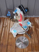 Overview of the Delta mitre saw from the front showing base, blade guard, dust bag and handle; general tool condition visible.