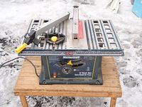 Front angled photo of the Mastercraft 10-inch table saw on wooden pallet placed on snow-covered ground.