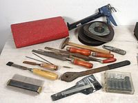 Overview of vintage tool lot including files, chisels, sanding pad, abrasive discs, caliper, and a box with drill bits and other small hand tools