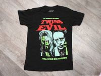 Front view of black T-shirt with Twins of Evil 2019 tour print featuring caricatures of Rob Zombie and Marilyn Manson.