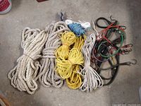 Photo showing mixed utility ropes and bungee cords arranged on a floor.