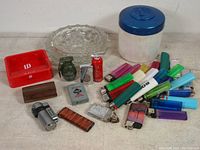Full lot showing lighters, ashtrays, Players tin, collectibles spread out on a flat surface